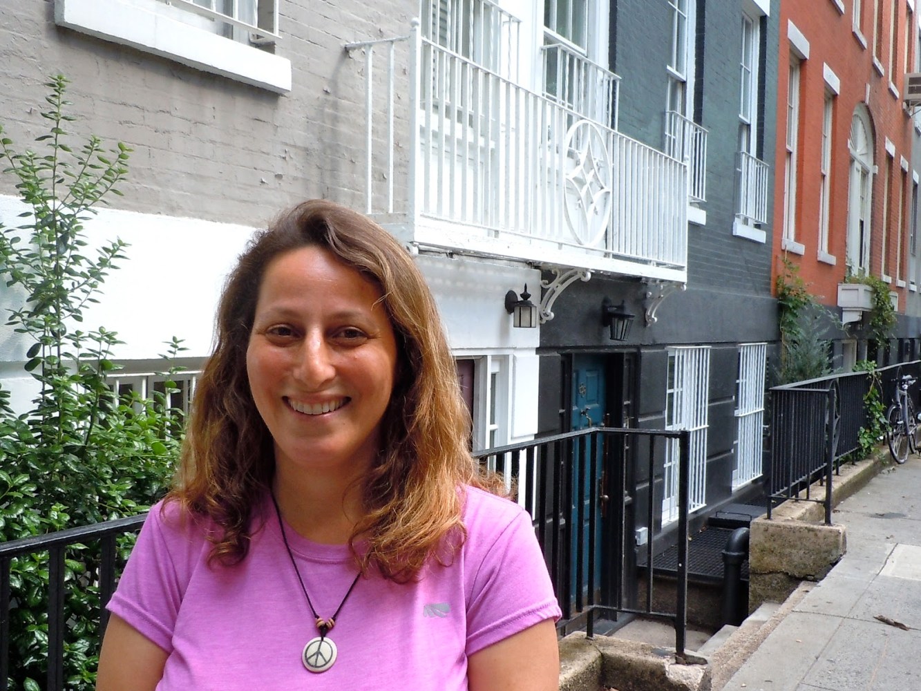 a girl in a pink shirt in front of a building