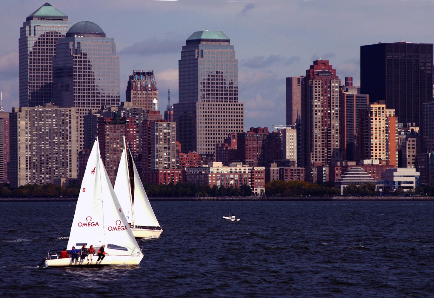 a small boat in a body of water with a city in the background