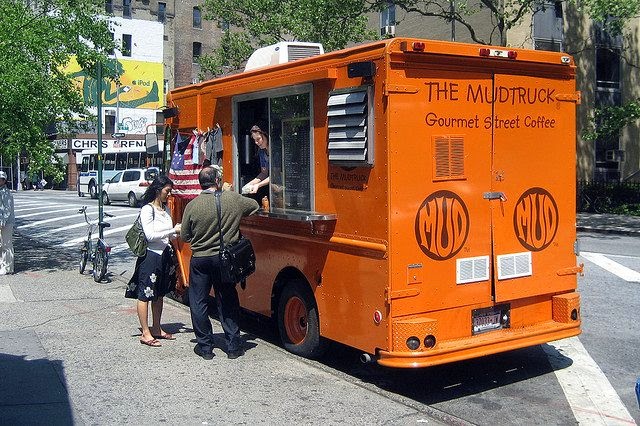 073114mudtruck a man with an orange bus is parked on the side of a road