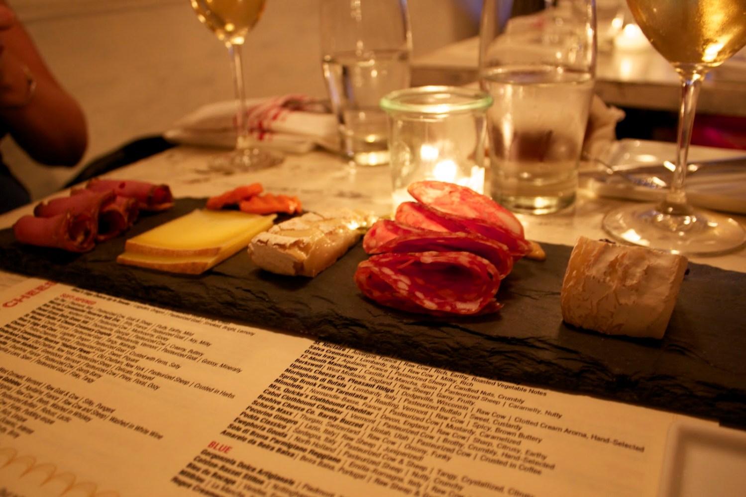 a person sitting at a table with wine glasses
