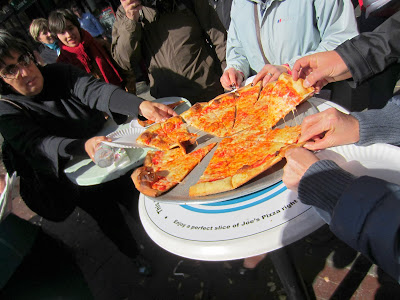 a group of people eating pizza