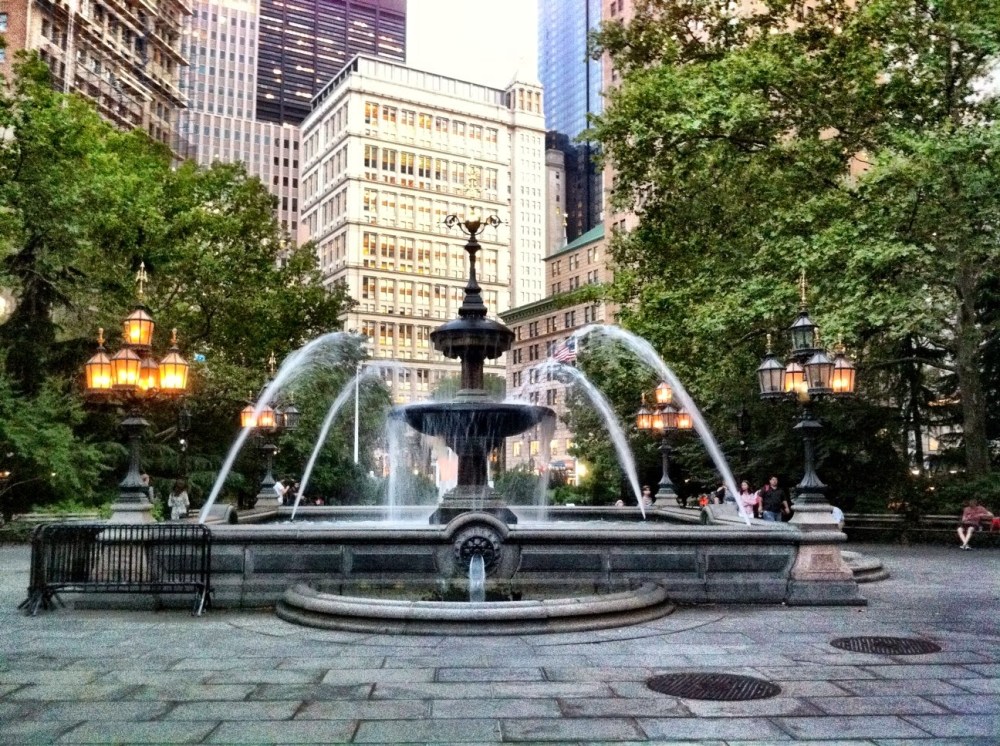 a fountain in front of a brick building