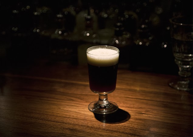 a glass of wine sitting on top of a wooden table