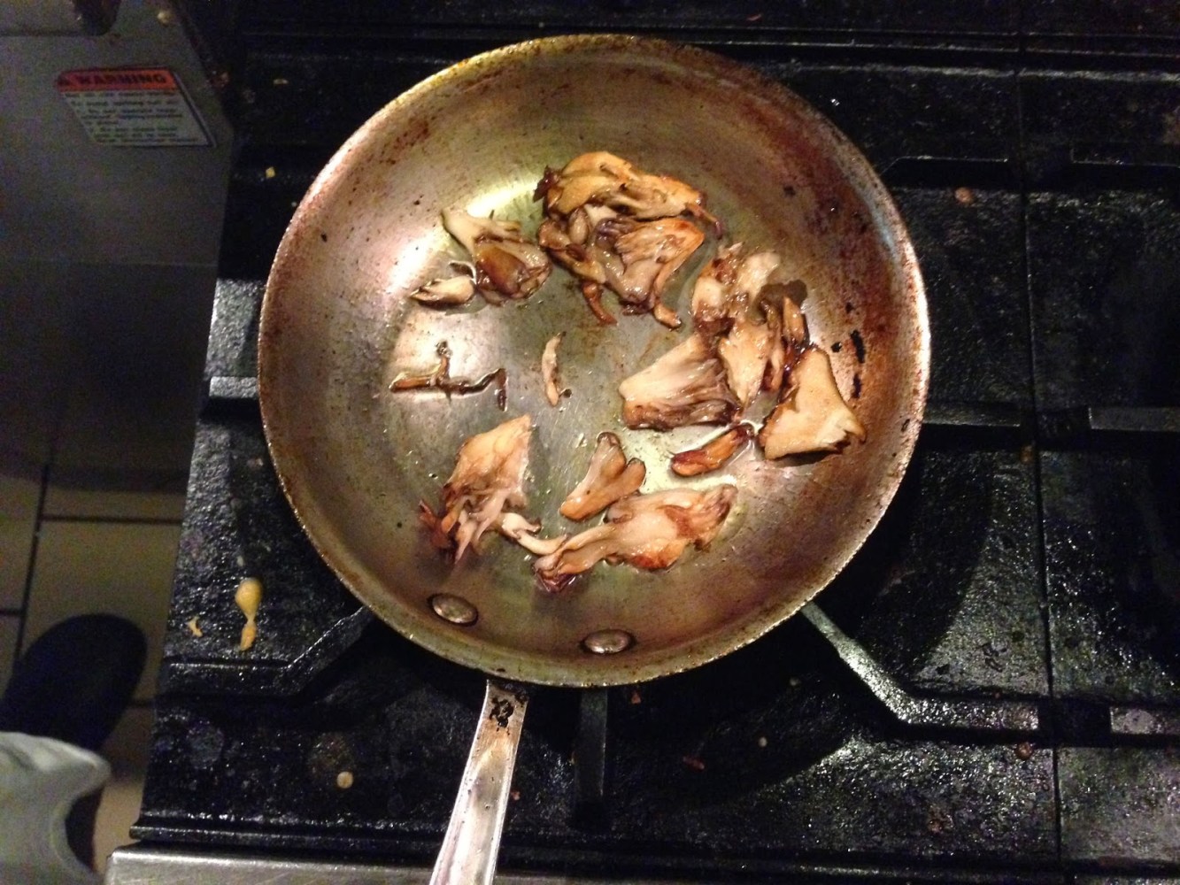 a pizza sitting on top of a metal pan on a stove