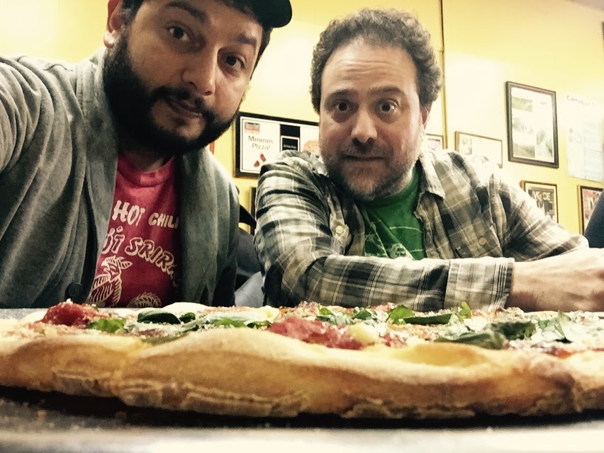 a man sitting in front of a large sandwich