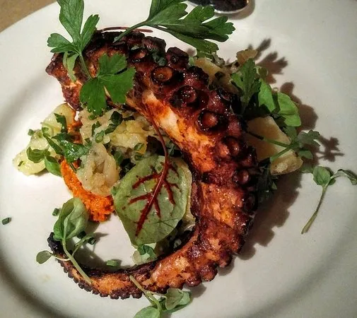 charred-octopus a plate of food with broccoli