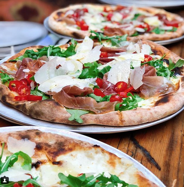 Screen-Shot-2018-05-18-at-2.05.07-PM a plate of food with a slice of pizza on a wooden table