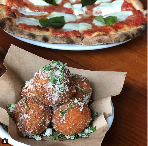 a pizza sitting on top of a wooden table