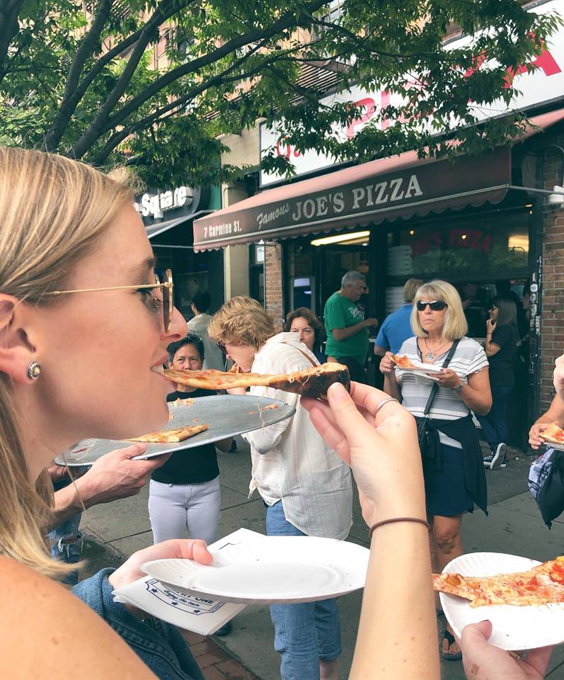 a woman eating a slice of pizza