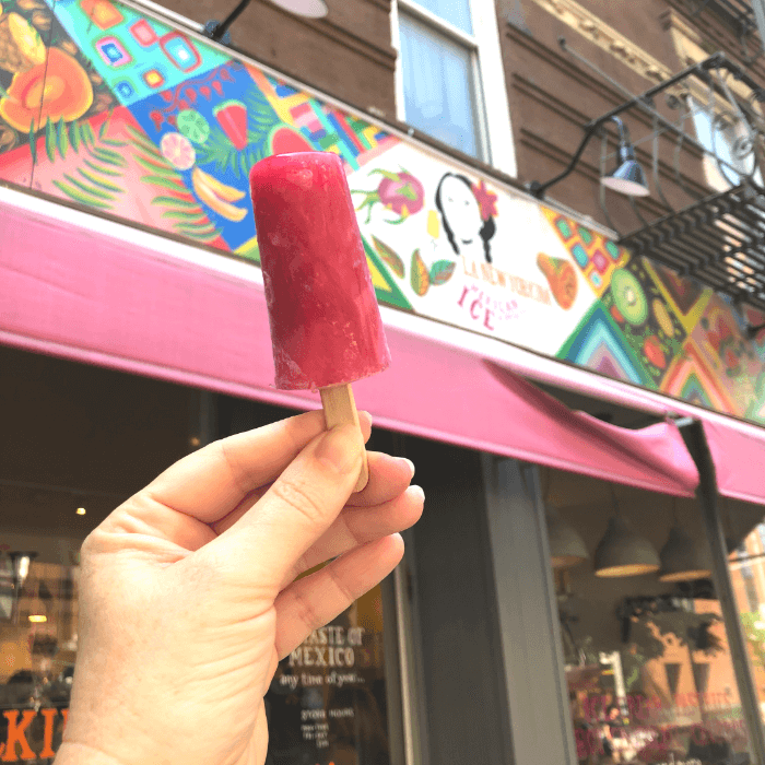 a hand holding a pink umbrella