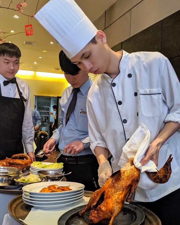 a man and woman preparing food in a kitchen