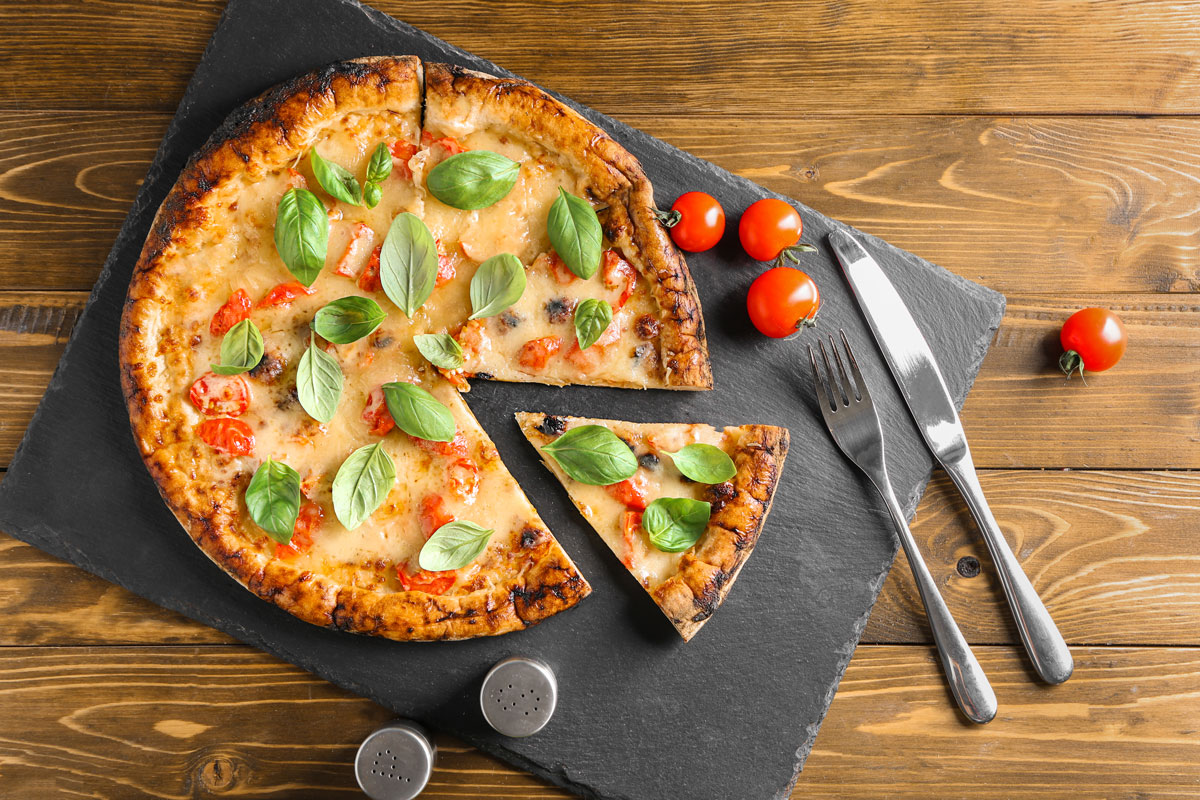 little-italy-food-tour-in-nyc-guided-culinary-exploration-img a pizza sitting on top of a wooden cutting board