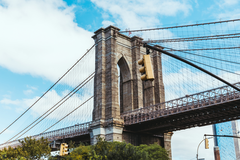 brooklyn-bridge-walking-tour-guide-and-tip a train traveling over a bridge