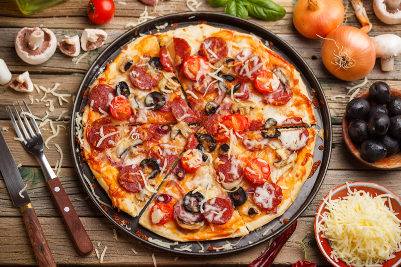 rated-by-locals-x-best-pizza-places-in-greenwich a pizza sitting on top of a wooden table