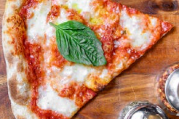 a slice of pizza sitting on top of a wooden table