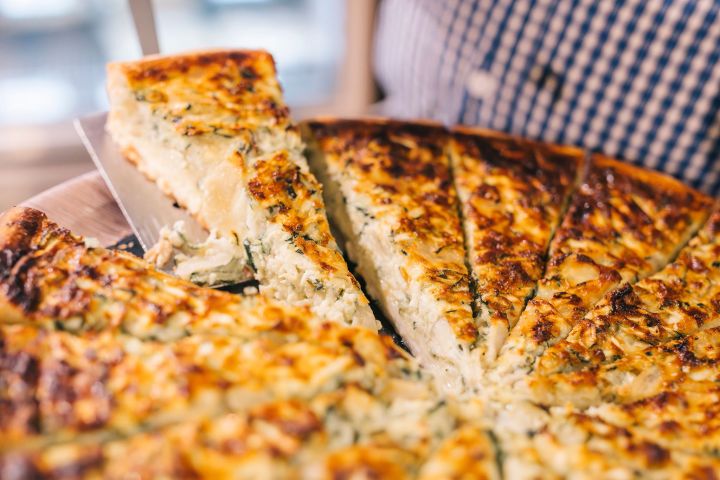 a close up of a pizza on a cutting board with a cake
