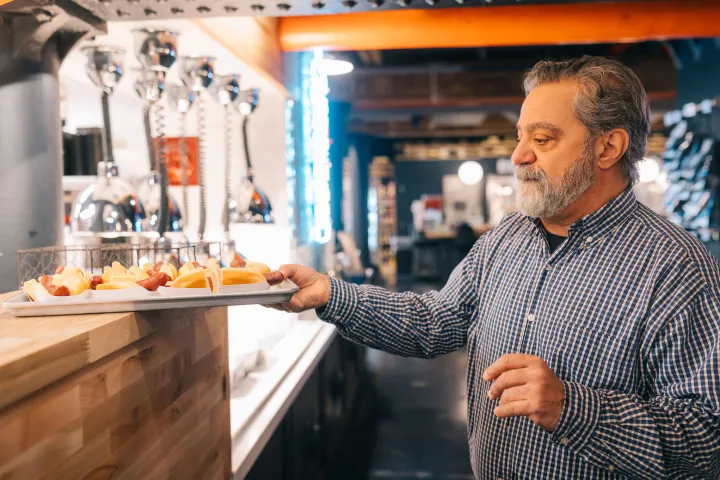 a man standing in a kitchen preparing food