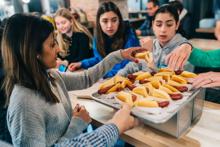 a group of people sitting at a table with food