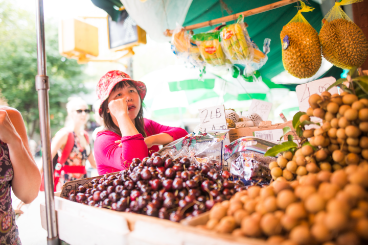 a group of people at a fruit stand