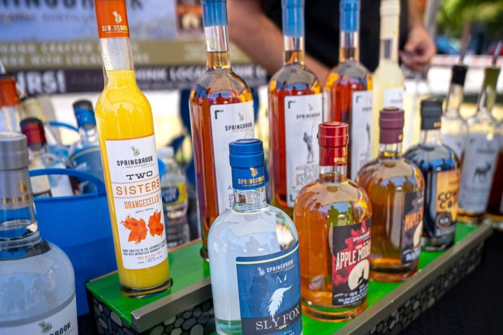 a man standing next to a bottle of beer on a table