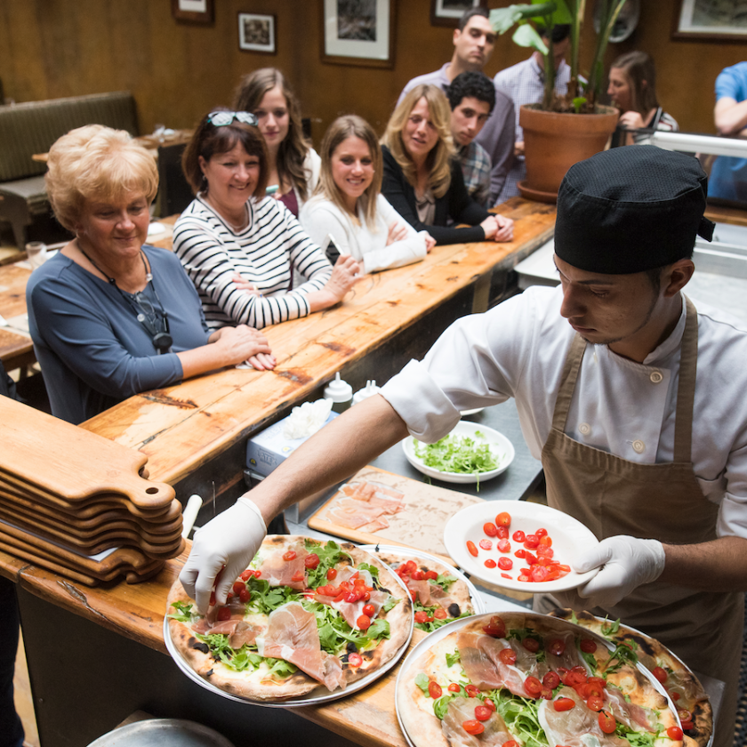 a group of people sitting at a table with food