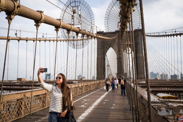 a woman standing on Brooklyn Bridge