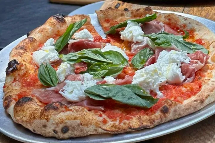 a pizza sitting on top of a plate of food on a table