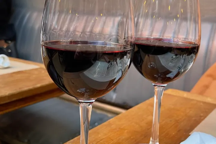 a glass of wine sitting on top of a wooden table