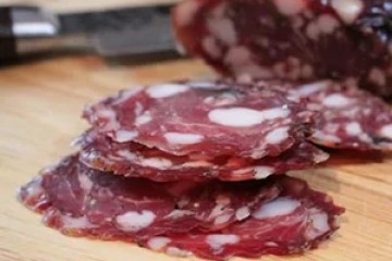 a slice of pizza sitting on top of a wooden cutting board