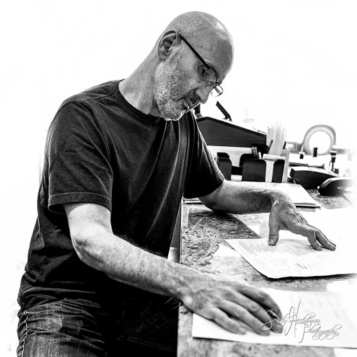 a man sitting on a cutting board