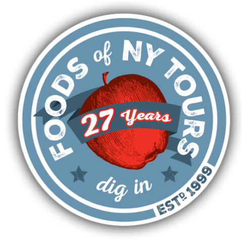 Round emblem for Foods of NY Tours, featuring a red apple and '27 years' text.