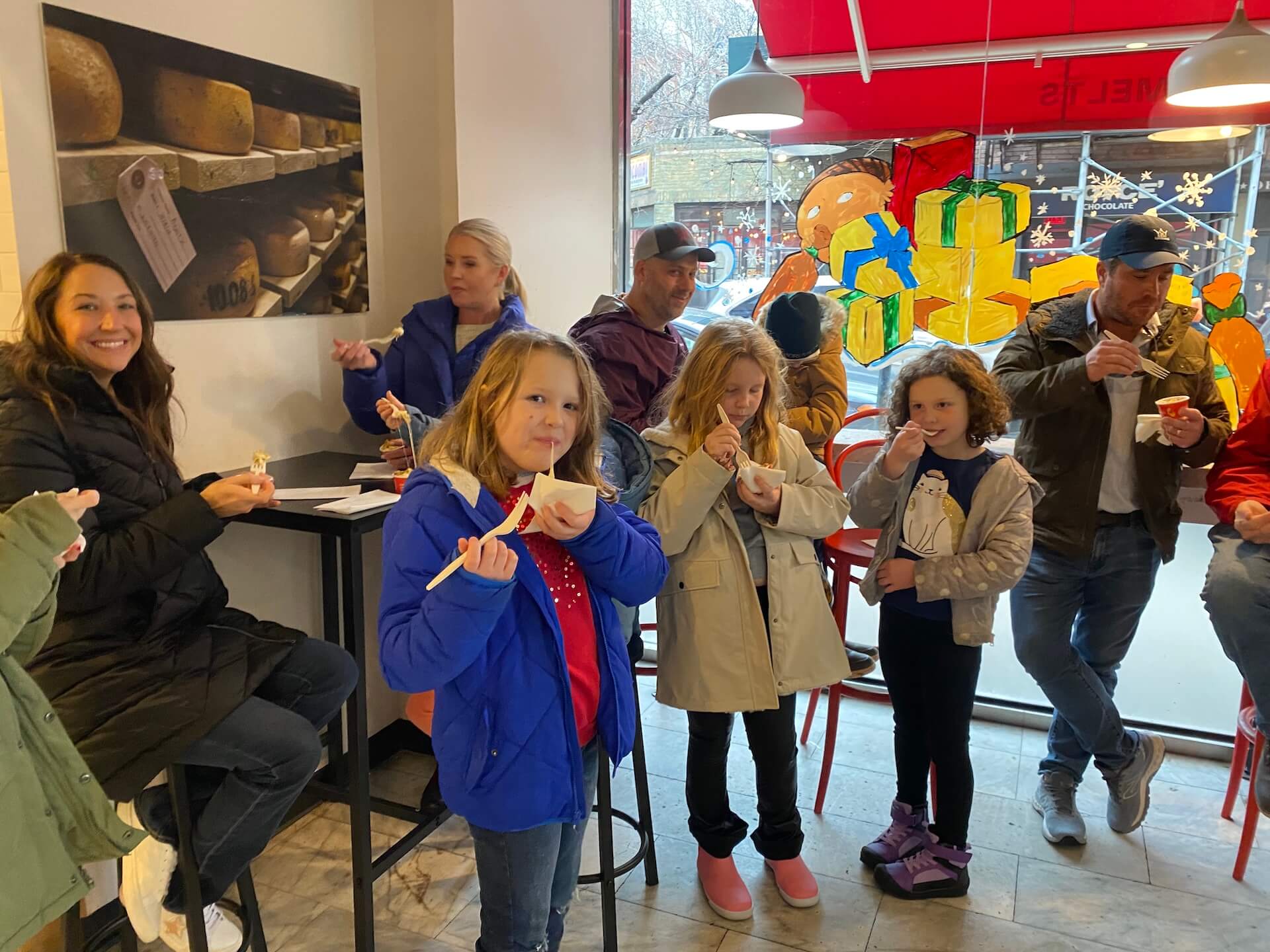 People enjoying ice cream in a cozy indoor cafe with bright decor.